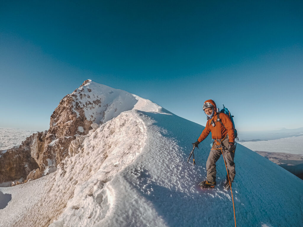 Climbing Pico De Orizaba man standing on the  summit ridge with the 18,500ft summit in the background. Rob Wessels Outdoors photography 