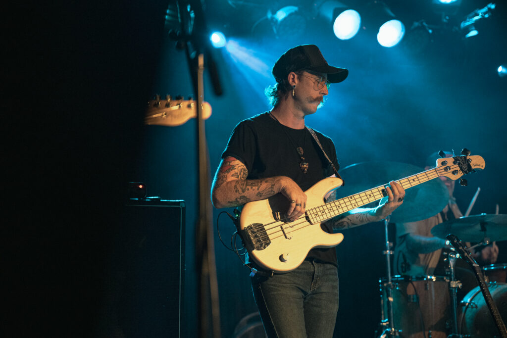 Bass player with blue stage light behind him