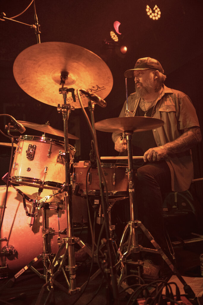 drummer playing the drums in warm gold light