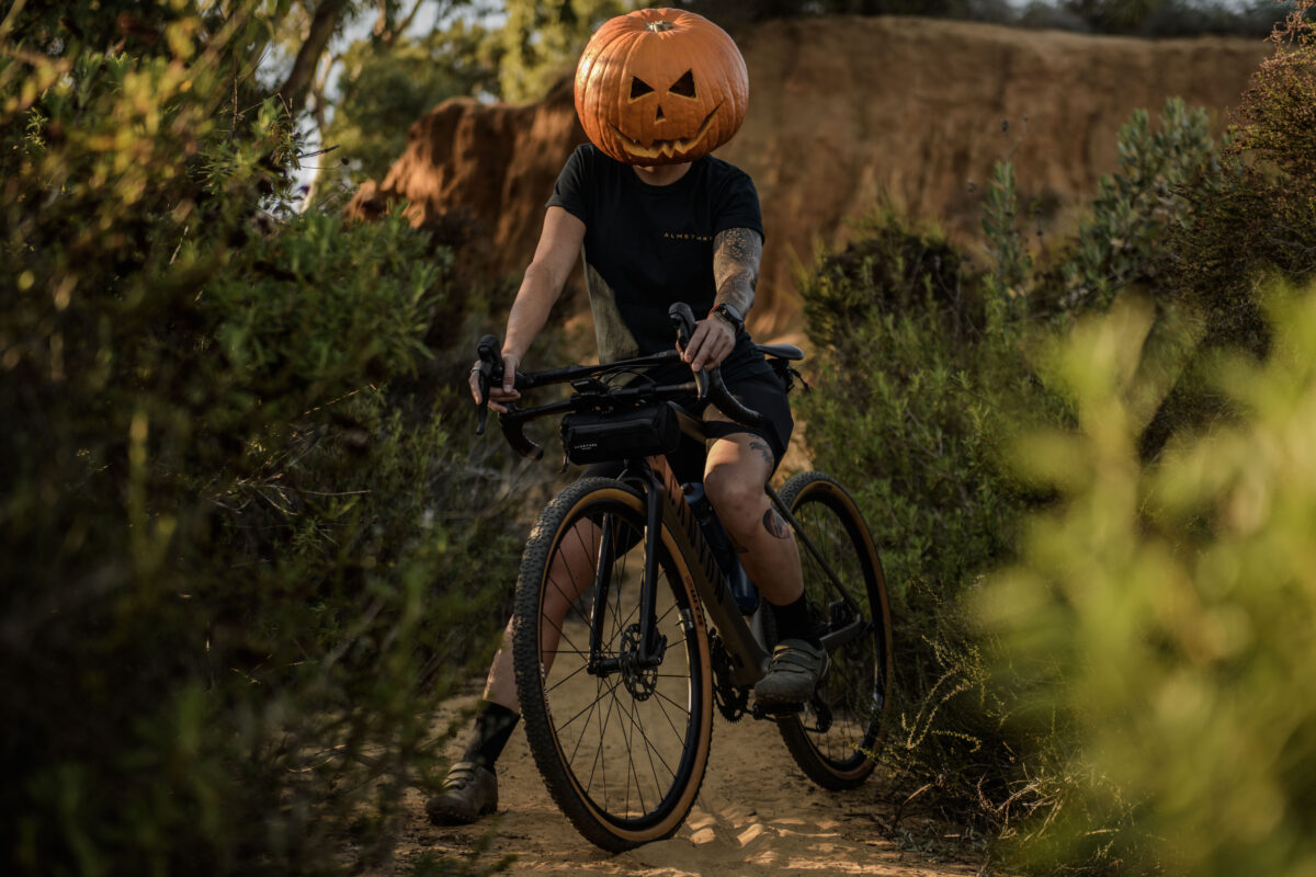 Halloween brand photography, gravel cyclist with a pumpkin helmet